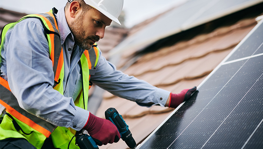man drilling solar panel 