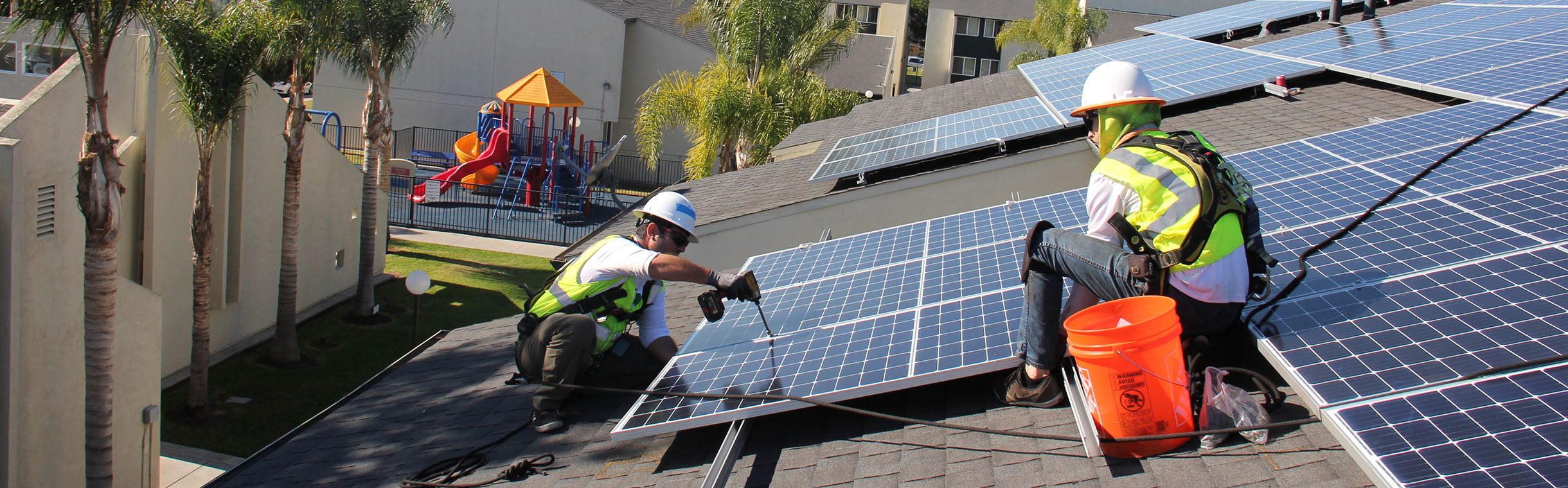 two workers installing solar on a rooftop