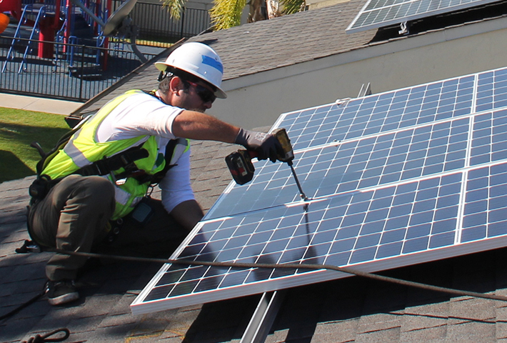 two workers installing solar on a rooftop