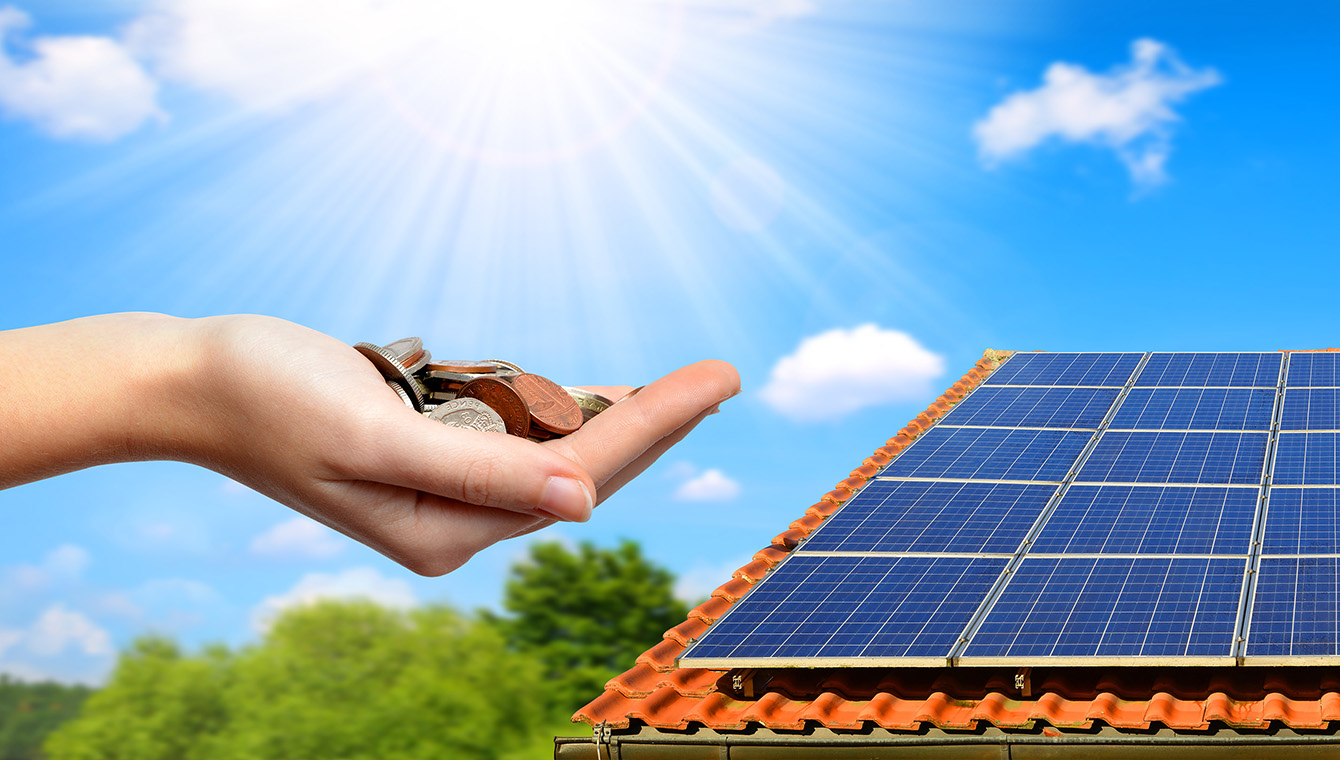 hand with coins next to a solar PV roof