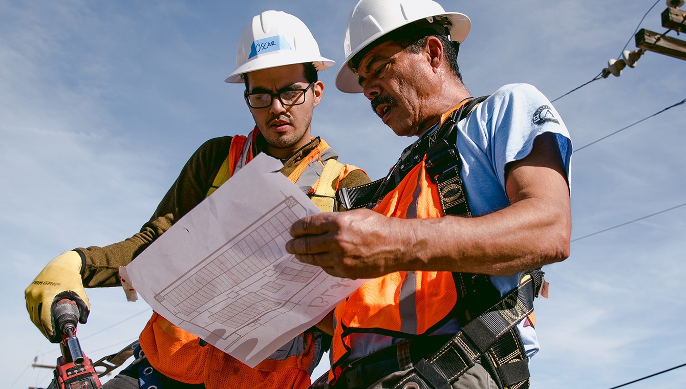 Two working hats men looking at drawings