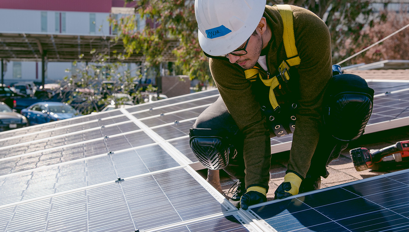 technician working on top of a solar PV system