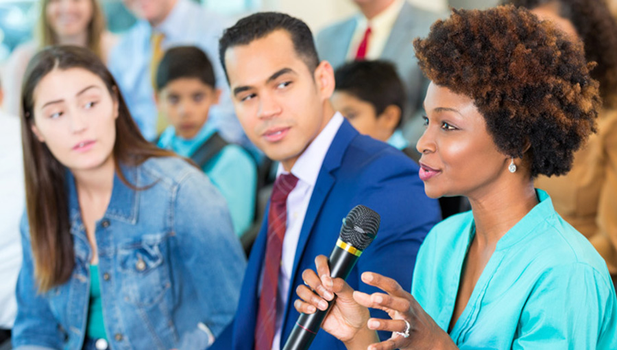 lady speaking and holding a microphone on a meeting